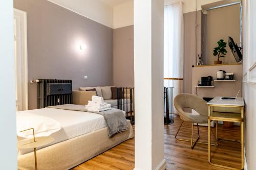 a bedroom with a bed and a table and a chair at Turin Central Cavour in Turin