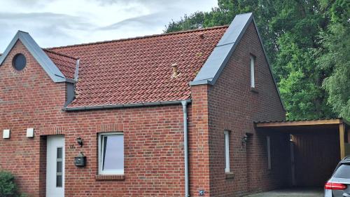 a red brick house with a black roof at Loft Hesel, 35232 in Hesel