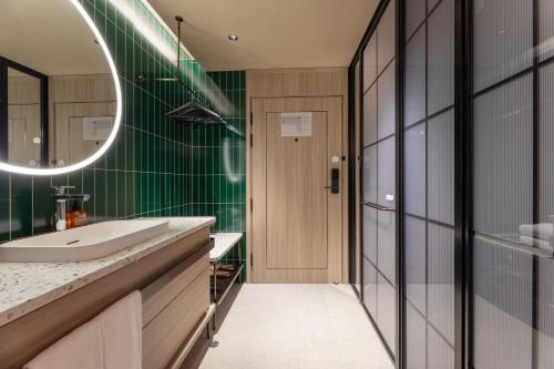 a bathroom with a sink and a mirror at Orange Hotel Hangzhou Joy City in Hangzhou