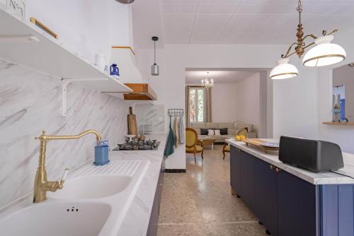 a kitchen with a sink and a living room at L'Ecrin des Corbières in Treilles