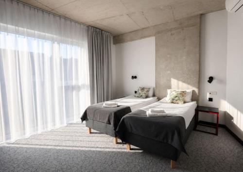 a hotel room with two beds and a large window at Arche Hotel Piła in Piła