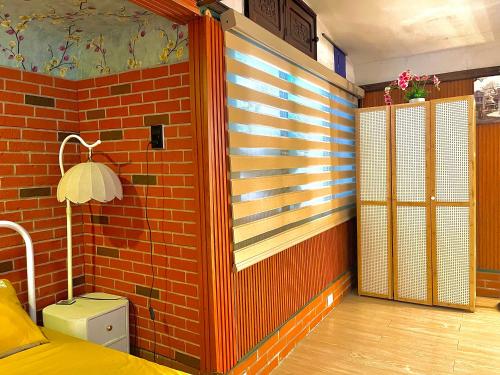a bedroom with a red brick wall and a window at Old House Homestay in Hanoi