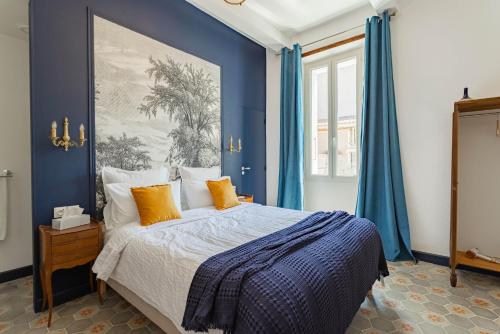 a bedroom with blue walls and a bed with orange pillows at L'Ecrin des Corbières in Treilles