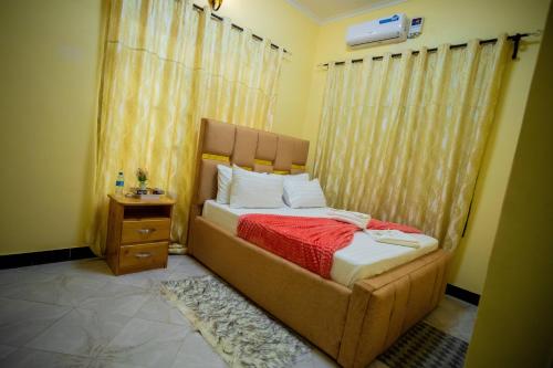 a bedroom with a large bed with a red blanket at Pristine Stays in Moshi