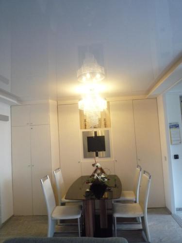 a dining room with a table and chairs and a chandelier at Private Apartment Laatzen City in Hannover