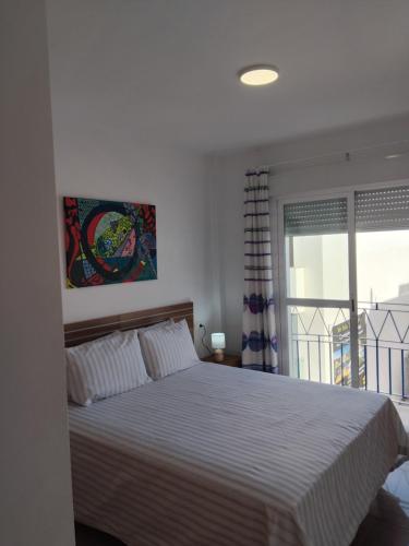 a bedroom with a large bed and a window at EDIFICIO SANTA GEMA 2k in La Cala de Mijas
