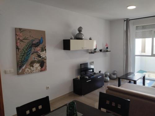 a living room with a peacock painting on the wall at EDIFICIO SANTA GEMA 2k in La Cala de Mijas