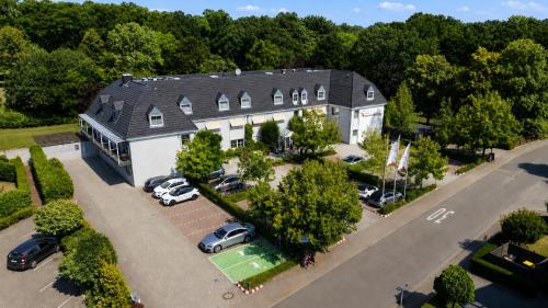 an aerial view of a large house with cars parked in a parking lot at NordWest-Hotel Bad Zwischenahn in Bad Zwischenahn