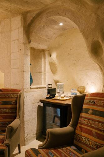 a room with a table and chairs in a stone room at Cappadocia Cave Suites in Göreme