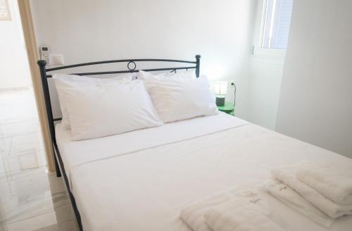 a white bed with white sheets and pillows at The Rock Seaside House - Etheras Properties in Kythira