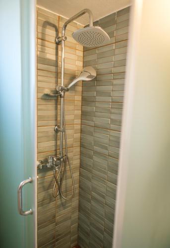 a shower with a shower head in a bathroom at The Rock Seaside House - Etheras Properties in Kythira