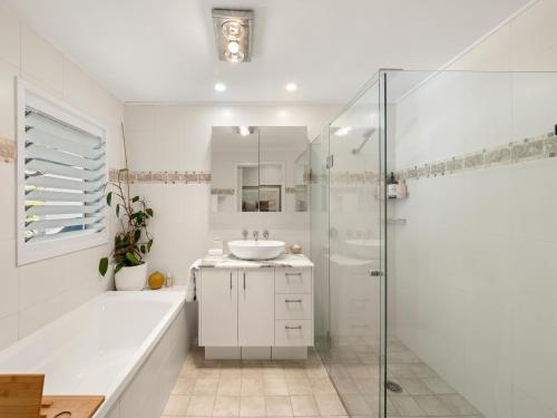 a white bathroom with a sink and a shower at Fairview in Rosebank