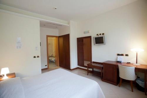 a bedroom with a white bed and a desk and a computer at Euroterme in Bagno di Romagna