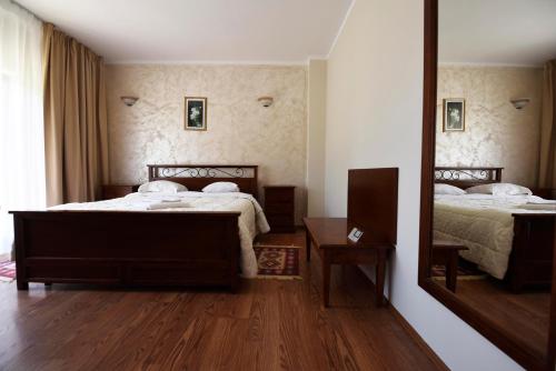 ein Schlafzimmer mit zwei Betten und einem Spiegel in der Unterkunft Lazoo Experience in Pitaru