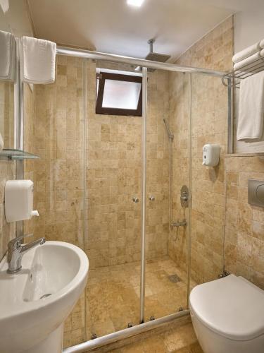 a bathroom with a shower and a sink and a toilet at La Paloma Hotel in Antalya