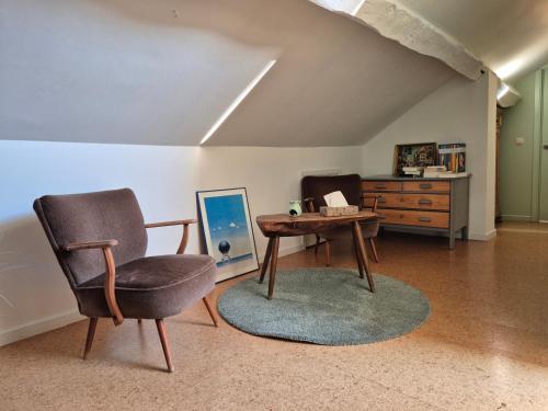 a living room with a chair and a table at Chambre de Camille à Gerpinnes in Gerpinnes