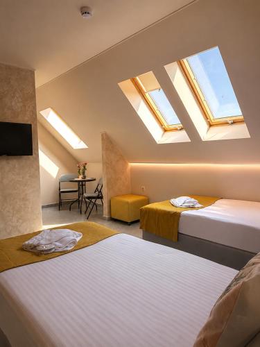 two beds in a room with skylights at Port Lake Hotel in Beloslav