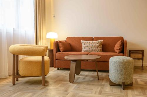a living room with a couch and a table at Hôtel Rotonde Aix-en-Provence centre in Aix-en-Provence