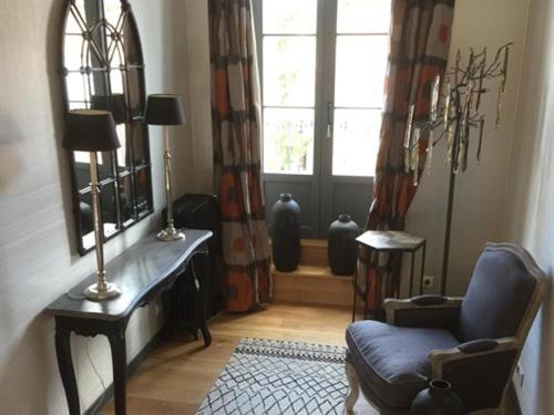 a living room with a chair and a mirror at L'Escale de Broglie in Broglie