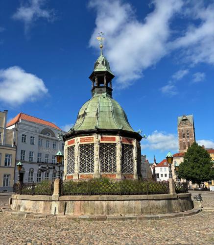 a gazebo with a green roof in a city at Dat Kleenood in Wismar