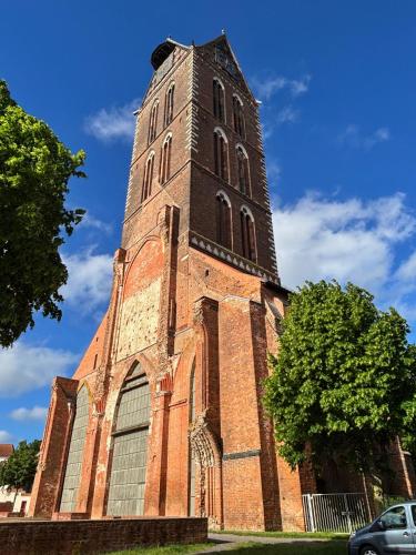 a tall brick church with a tall tower at Dat Kleenood in Wismar