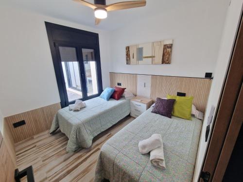 a bedroom with two beds and a ceiling fan at VILLA CALA LLARGA BEACH in Roses