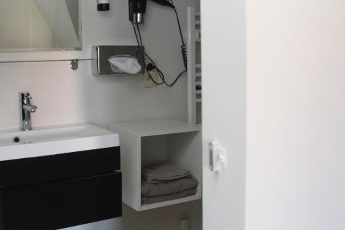 a bathroom with a sink and a mirror and towels at Villa Amylia & gratis parking in Wenduine