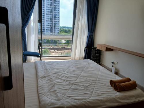 a bedroom with a bed with a large window at Marina vinhomes in Long Bình