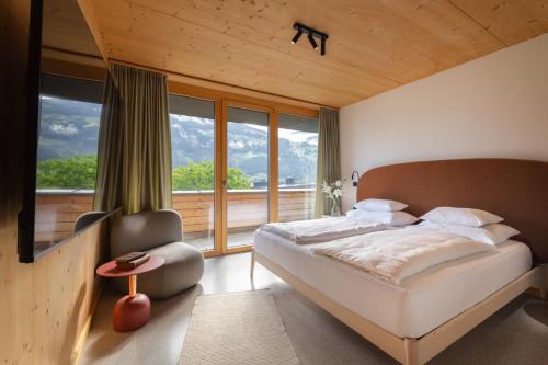 a bedroom with a bed and a large window at Mari Pop Hotel in Ried im Zillertal