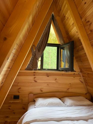 a bedroom in a log cabin with a window at TriView in Žabljak