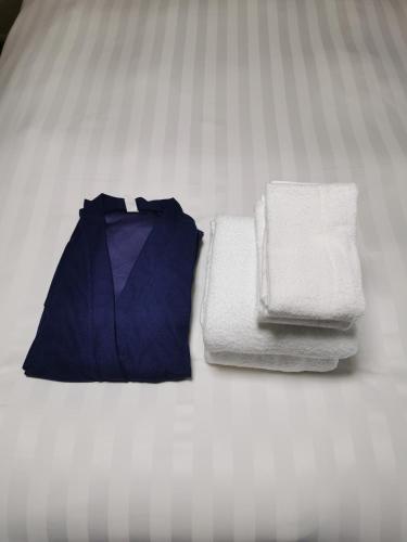 a group of towels and an umbrella on a bed at Villa9 in Onjuku
