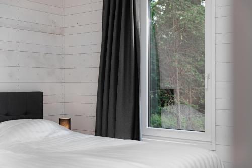 a bedroom with a bed and a large window at Summio Vakantiepark Schaijk in Schayk