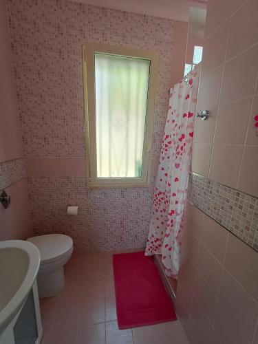 a bathroom with a toilet a sink and a window at A due passi dal mare in Ribera