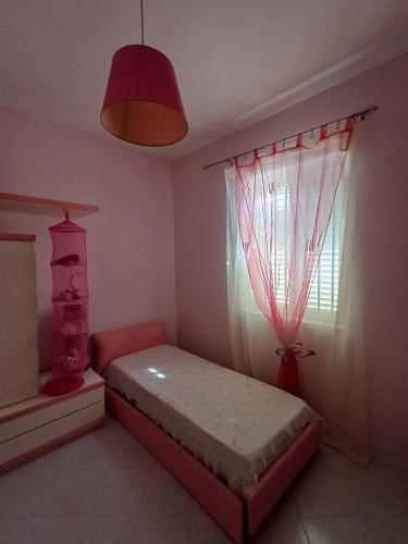 a bedroom with a bed and a window at A due passi dal mare in Ribera