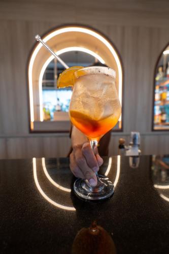 a person holding a drink with a lemon on a counter at Kantary Beach Hotel Villas & Suites in Khao Lak