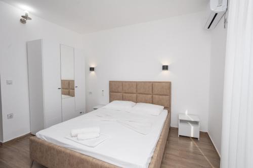 a bedroom with a large bed with white sheets at Babulje in Ulcinj