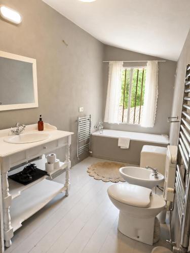 a bathroom with a sink and a toilet and a tub at Wisteria Lodge by Veneto Villa in Albignasego