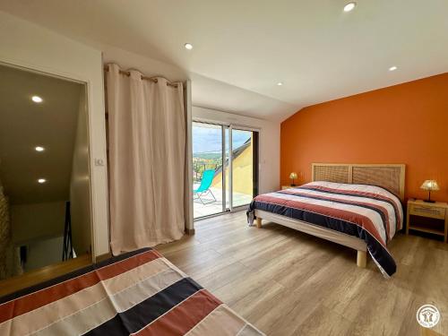 a bedroom with orange walls and a bed and a window at Le Creux Percé in Pasques