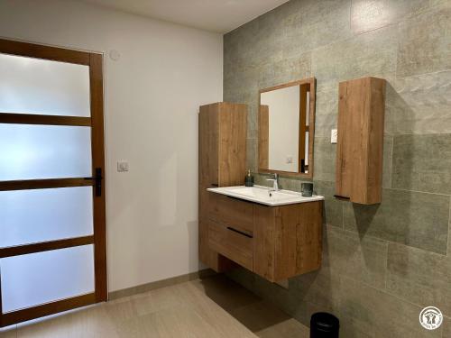 a bathroom with a sink and a mirror at Le Creux Percé in Pasques