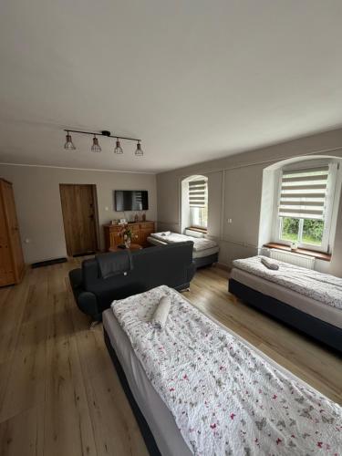 a large room with two beds and a couch at Chata na Karpackiej in Kostrzyca