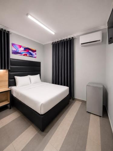 a bedroom with a large bed and a tv at Metro Lodge MP in Durban