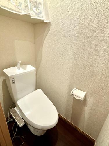 a small bathroom with a white toilet and a phone at Norah Stay Tokyo in Yashio