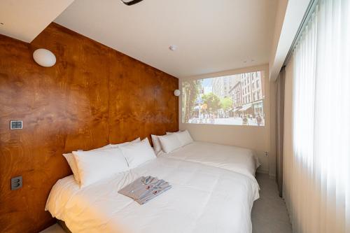 a bedroom with a large white bed with a wooden headboard at Monday Mansion Hotel in Seoul