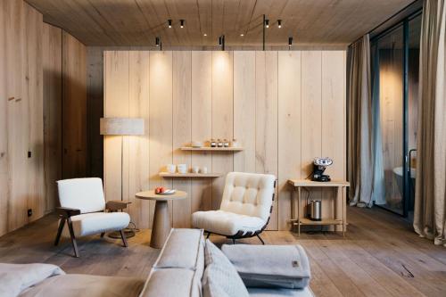 a room with a bed and two chairs and a table at Wiesergut in Saalbach-Hinterglemm