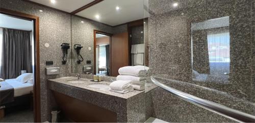 a bathroom with a sink and a shower with a mirror at Goldstar Resort & Suites in Nice