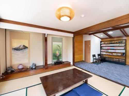 a living room with a table and a book shelf at Beni Fujien in Yamanakako