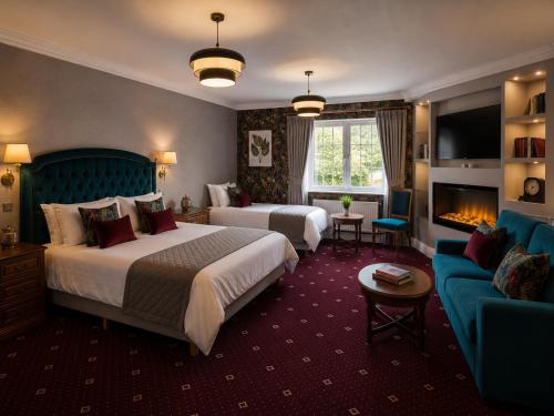 a hotel room with two beds and a couch at The Véro Townhouse Killarney in Killarney