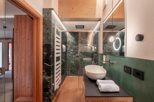 a bathroom with a sink and a glass shower at Casa Pencio in Pozza di Fassa