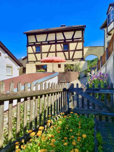 a wooden fence with an umbrella in front of a building at Torwärterhaus Kipfenberg-Arnsberg in Arnsberg