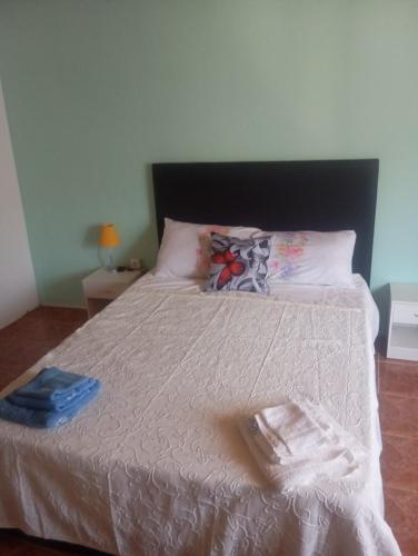 a bedroom with a bed with a white comforter at O cantinho d'abelheira in Falgueiras